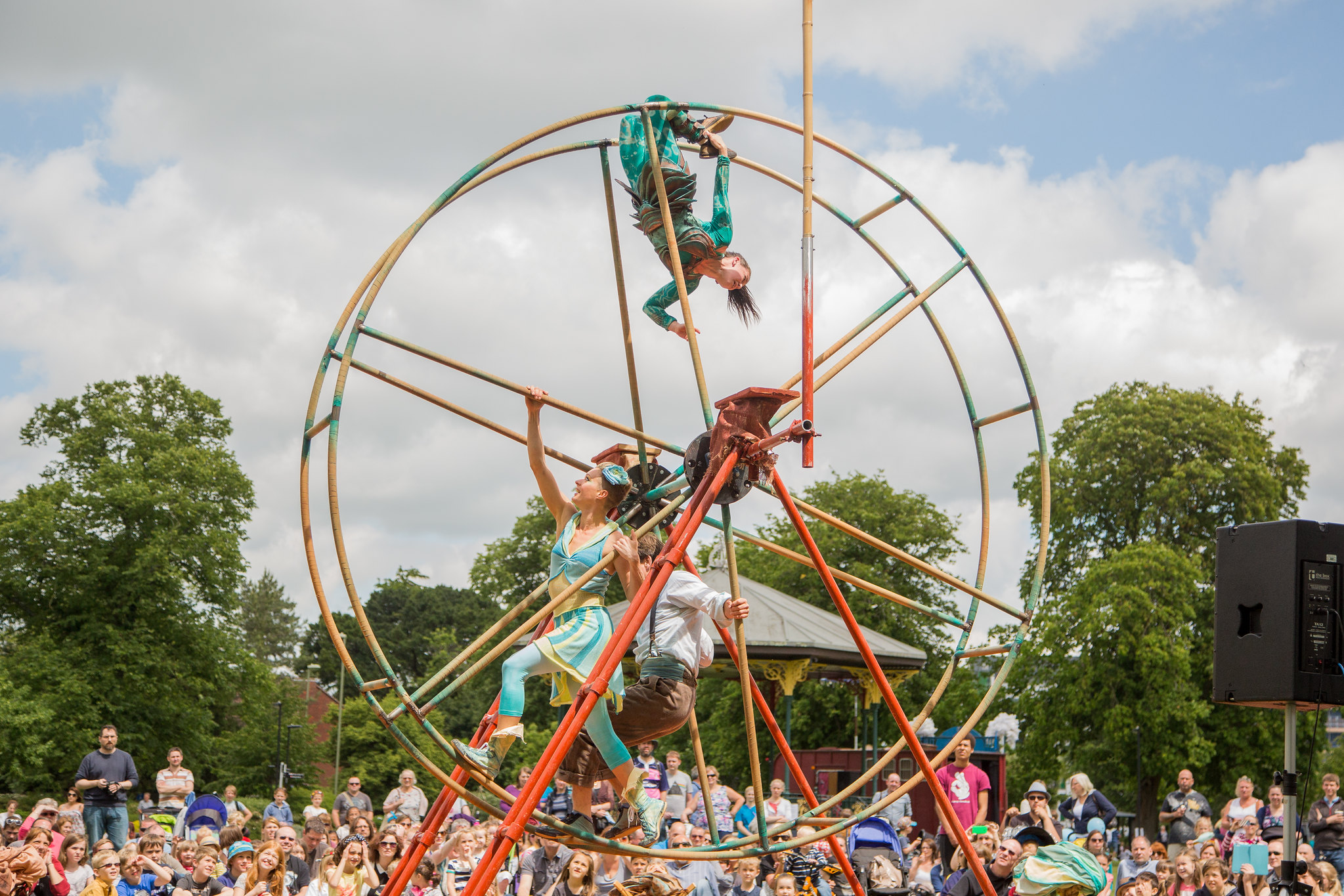People inside large wheel at arts festival