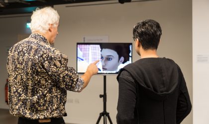 Person showing another person an image on a screen