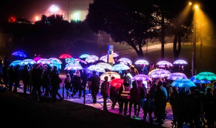 Group of people walking with illuminated umbrellas