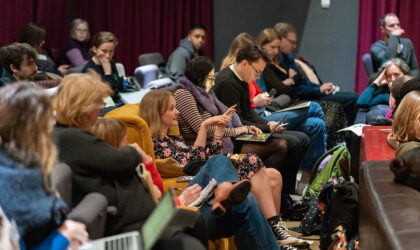 A row of people sit in cinema seats during a training session