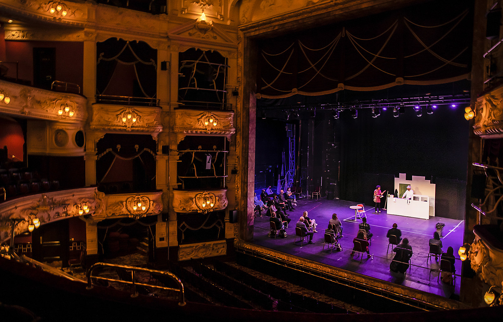 Performers on theatre stage in empty theatre