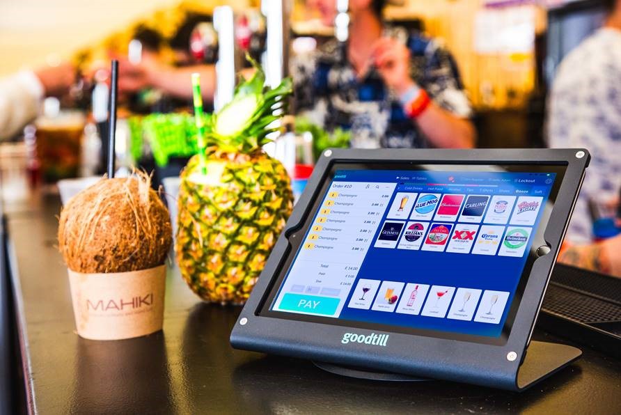 Image of laptop next to a pineapple and coconut containing drinks