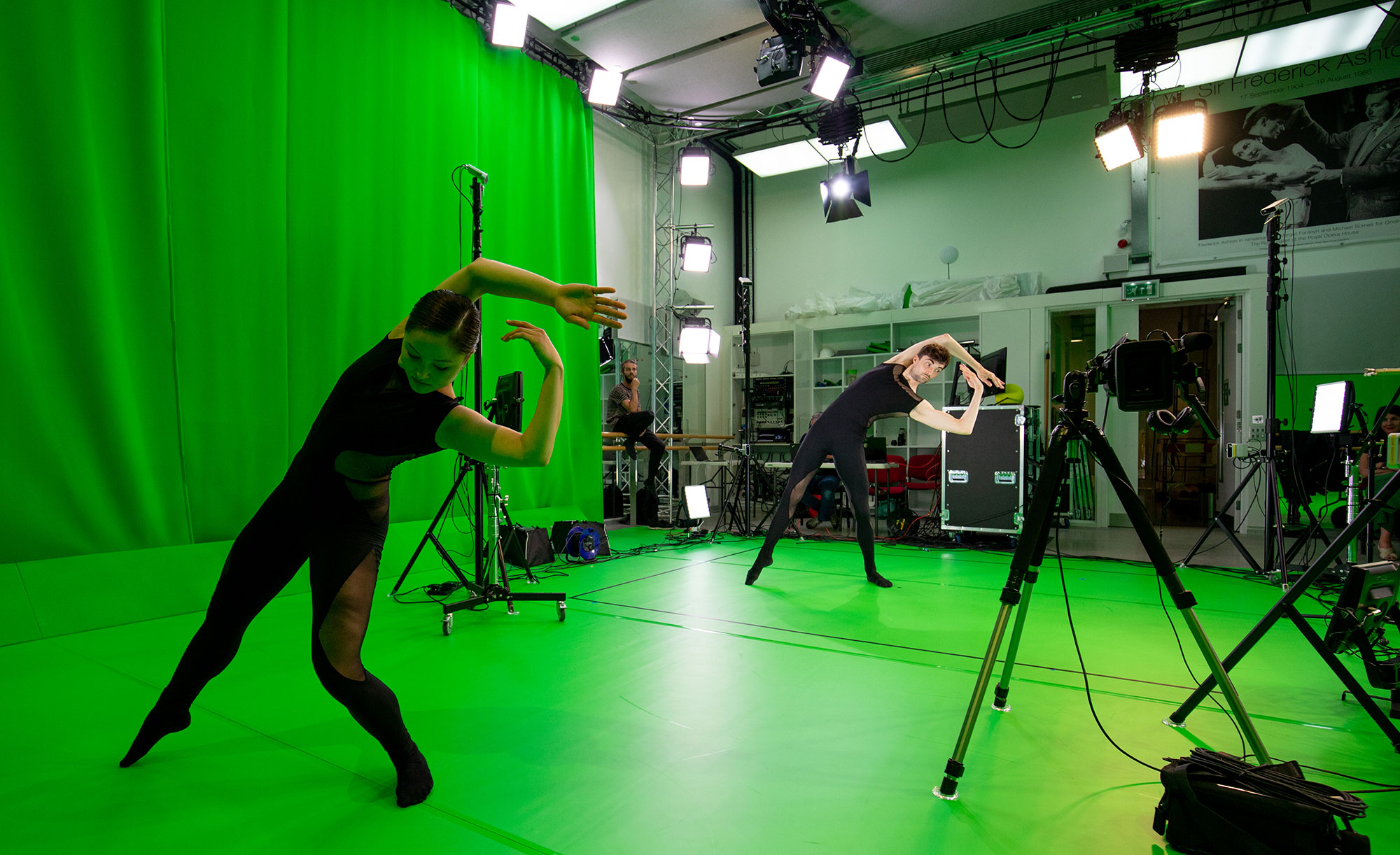 Two dancers performing in front of a green screen