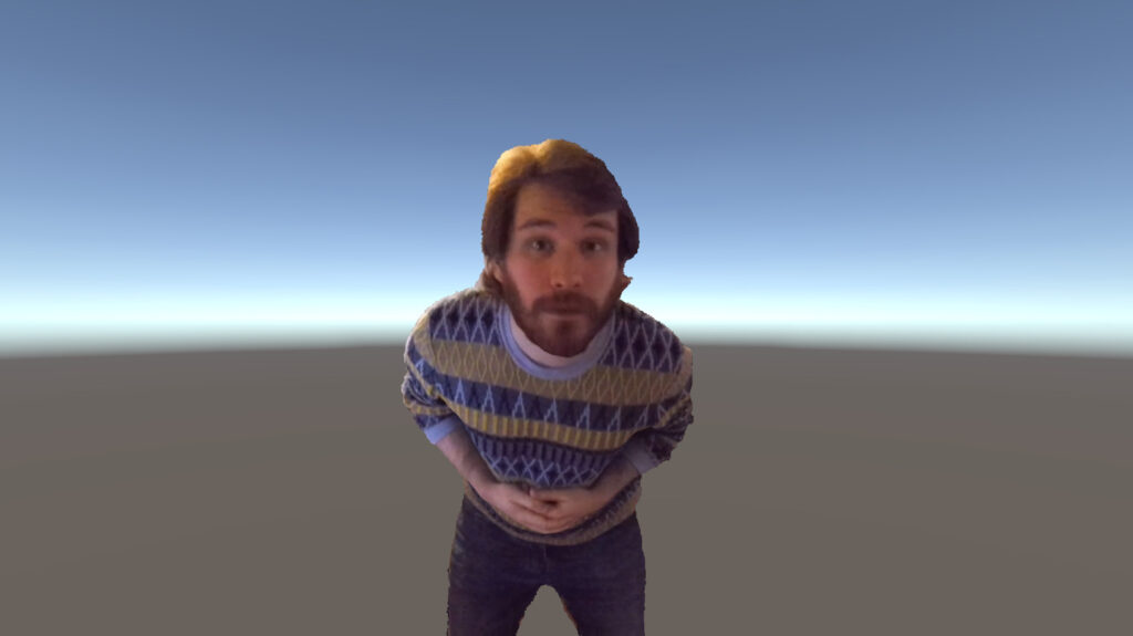 A bearded person wearing a patterned jumper leans forward in a virtual space.