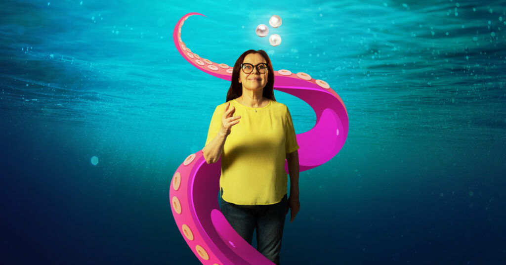 A woman with dark hair and glasses, wearing a yellow top is reaching her hand towards us. She appears underwater, and a large pink tentacle threatens to capture her. 